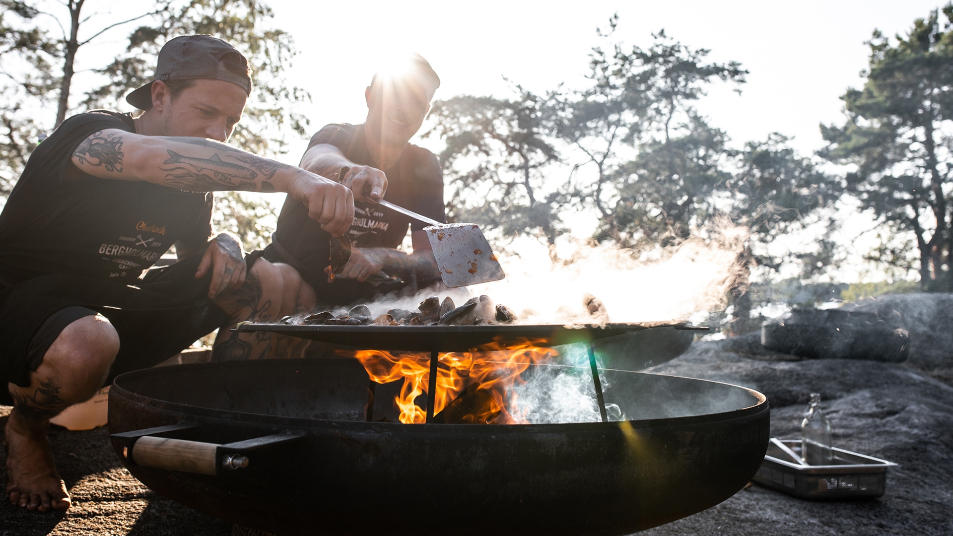 Zwei Jungs grillen an einer Feuerstelle für die Jack Wolfskin Kampagne #GOBACKPACK