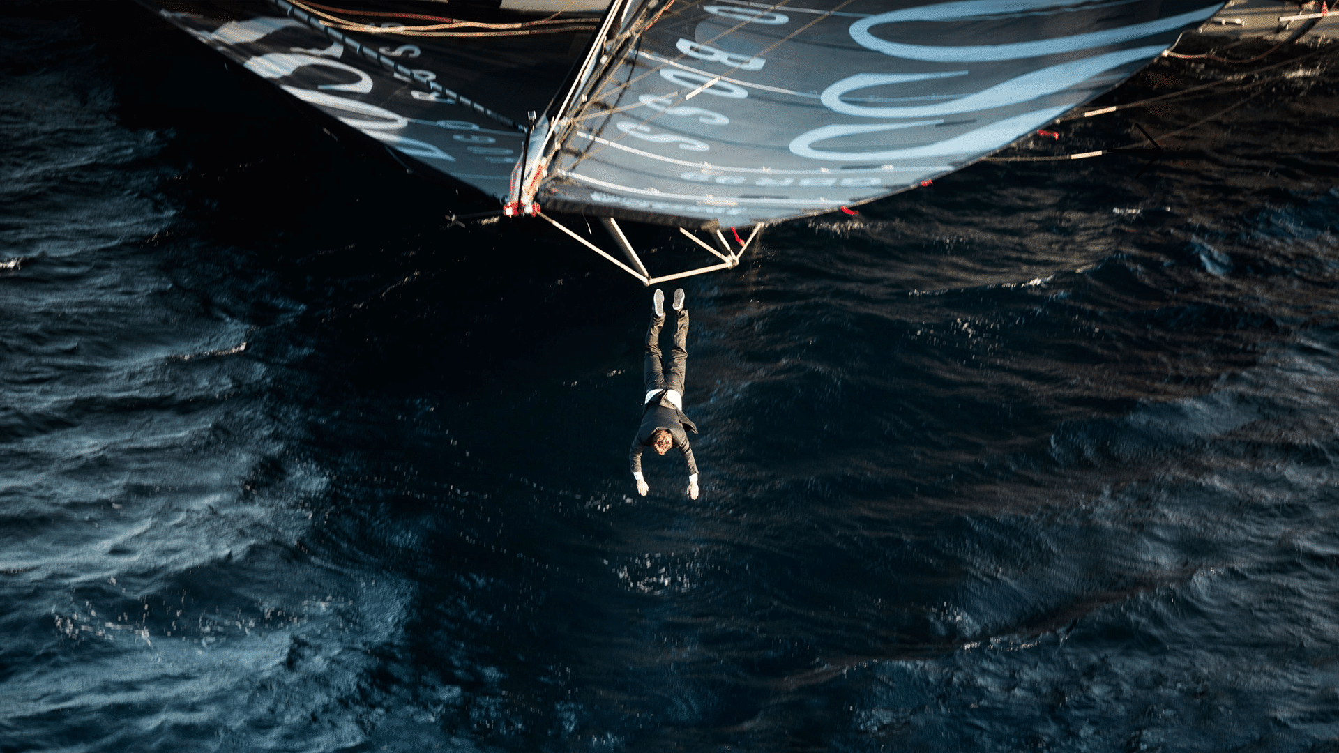 Mann springt von dem Segel eines Segelbootes für die Hugo Boss Social Media Kampagne