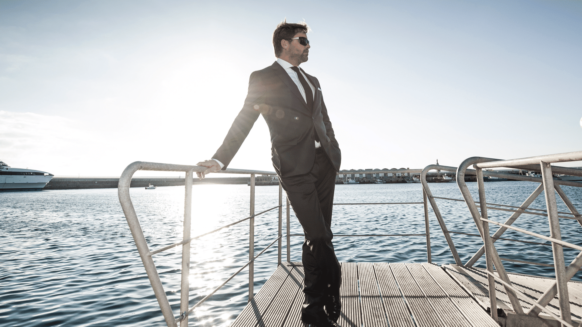 Mann im schwarzen Anzug steht am Hafen für die Hugo Boss Social Media Kampagne