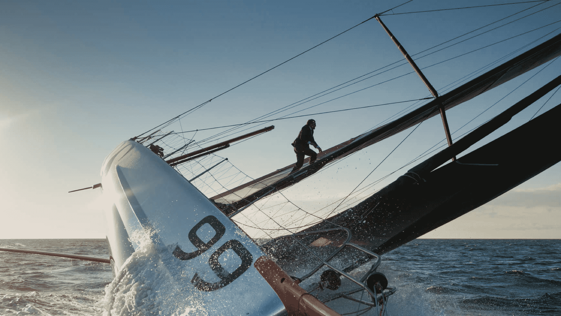 Mann im schwarzen Anzug läuft das Segel eines Segelbootes hoch für die Hugo Boss Social Media Kampagne