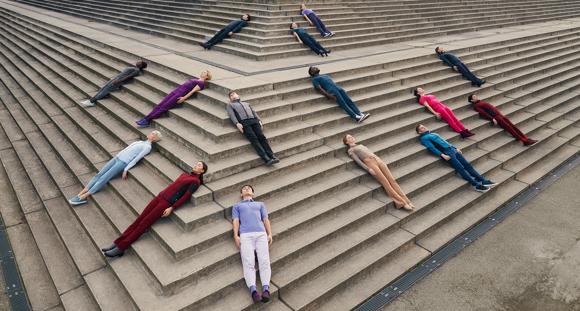 Bunt gekleidete Menschen liegen auf einer Treppe für das Hakro Inspirations Shooting