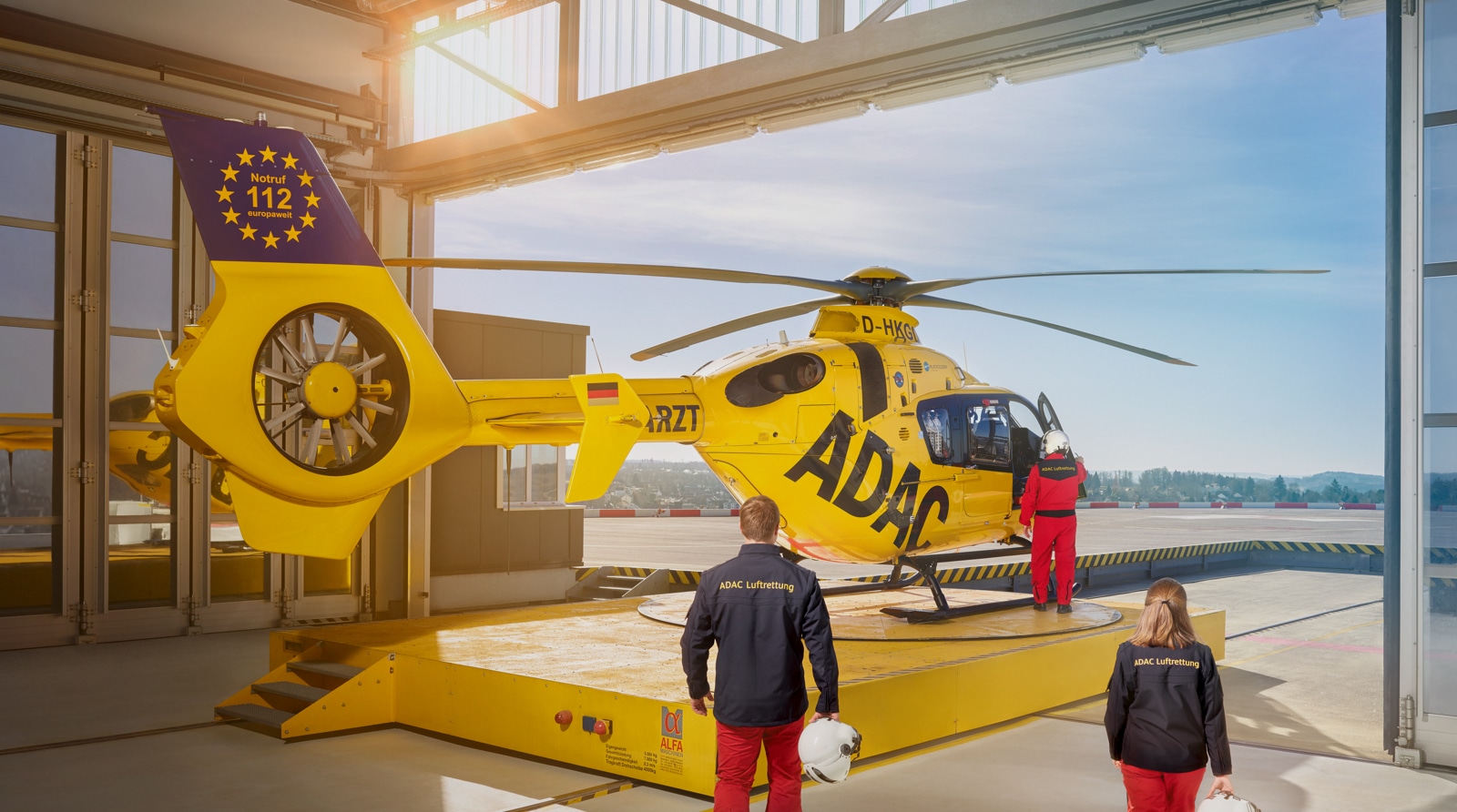ADAC Hubschrauber in der Garage, zwei Piloten steigen ein für die ADAC Kommunikationskampagne