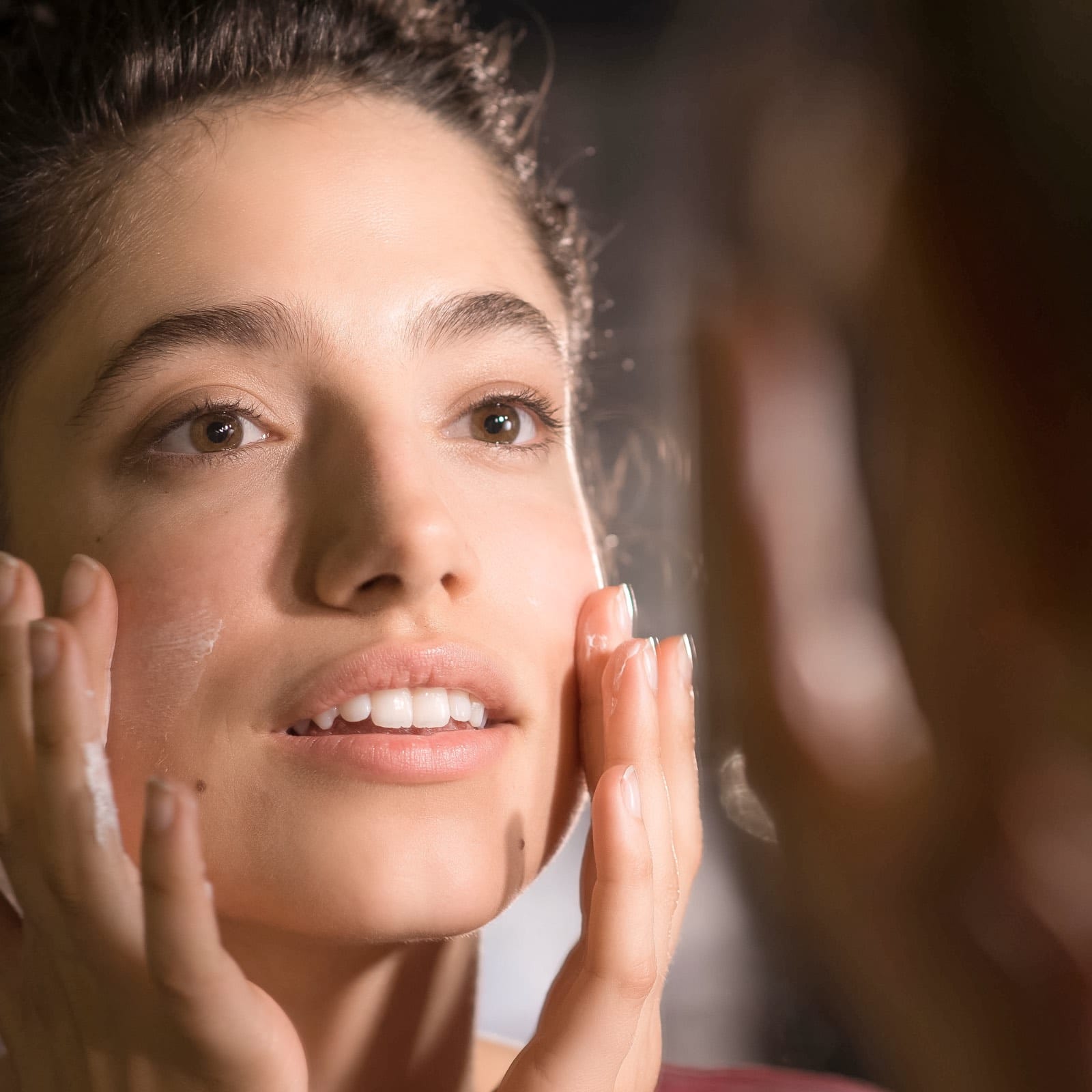 junge Frau cremt ihr Gesicht ein im Rahmen der Bio.Vegane Kampagne