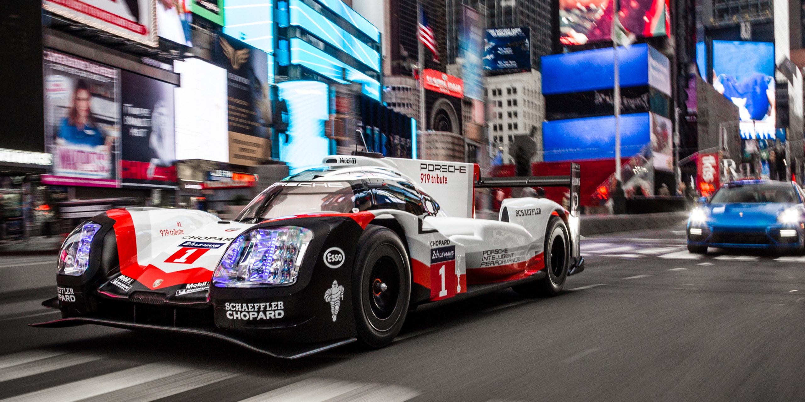 Porsche 919 auf einer Stadtstraße mit Gebäuden im Hintergrund