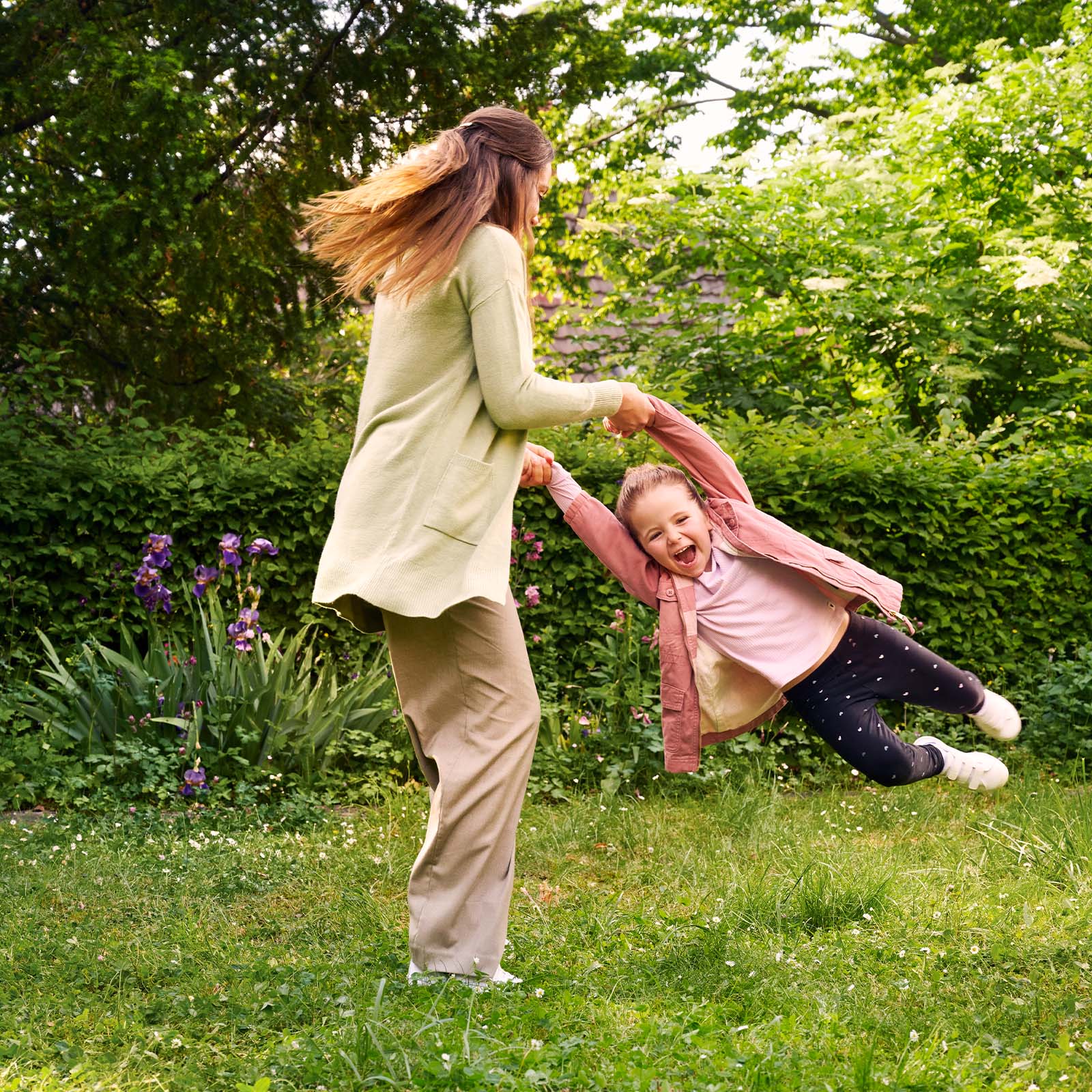 Mutter spielt mit ihrem lachenden Kind im Garten